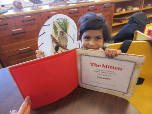 Student holding the book The Mitten holding artwork