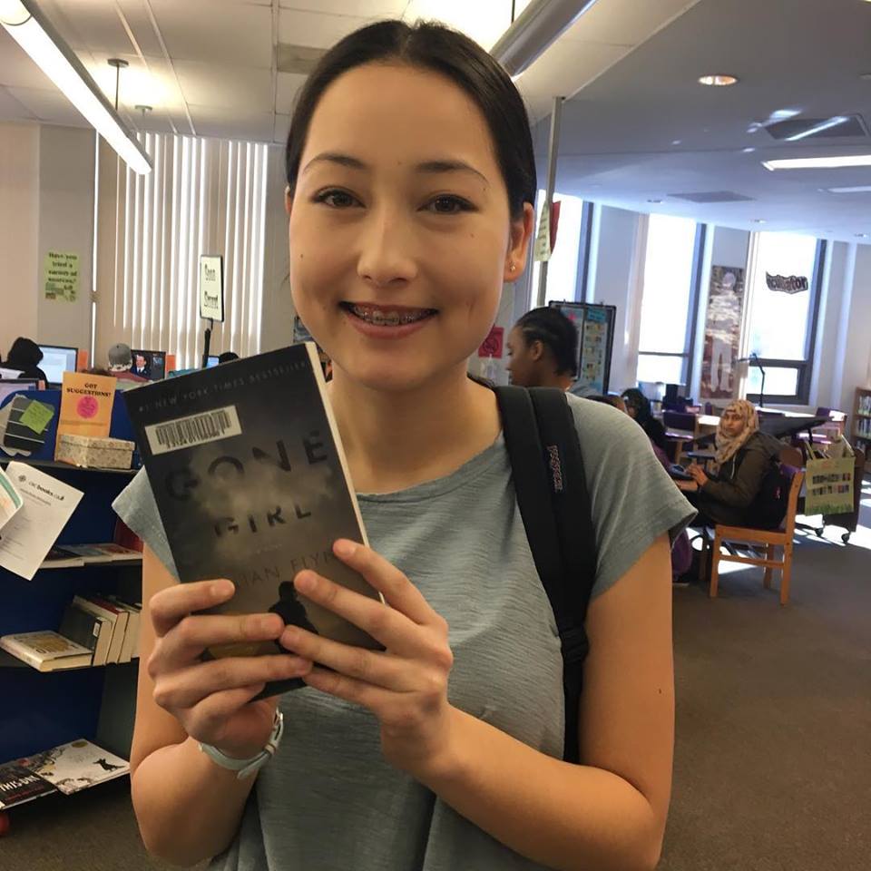student holds a book