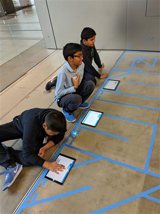 Students controlling robots on a tablet