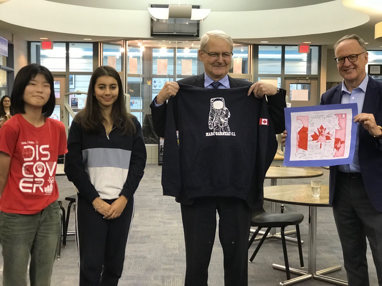 Honourable Marc Garneau Receiving a Gift of a sweat shirt from our students