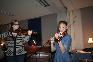 student and adult playing violins