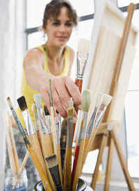 Woman reaching for paintbrush
