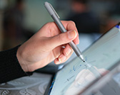 A student is seen using a stylus on a screen