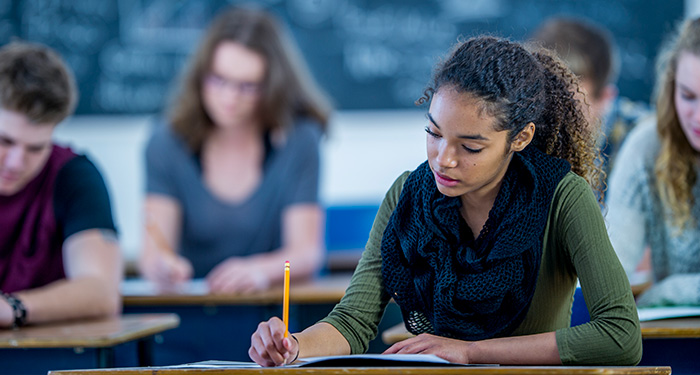 A classroom of serious high school students focus on taking the test