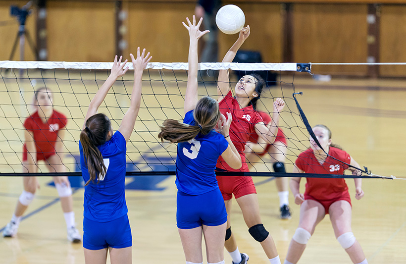 Two high school volleyball teams square off in an intense match