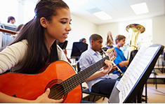 A student led orchestra practices both wind and string instruments