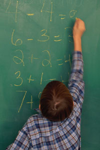 child writing on chalkboard