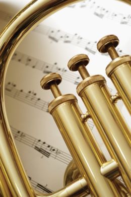 brass instrument with sheet music background
