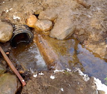A drainage pipe dug in by students to divert water from the trail